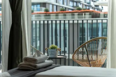a hotel room with a balcony with a bed and a chair at ZIGZAG Belgrade Waterfront Terra in Belgrade