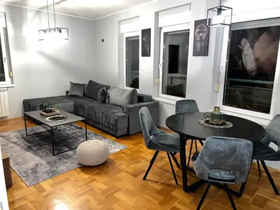 a living room with a couch and a table and chairs at Fairy tale apartment in Dušanovac (historical)