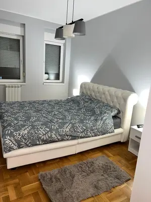 a bedroom with a bed and a couch at Fairy tale apartment in Dušanovac (historical)
