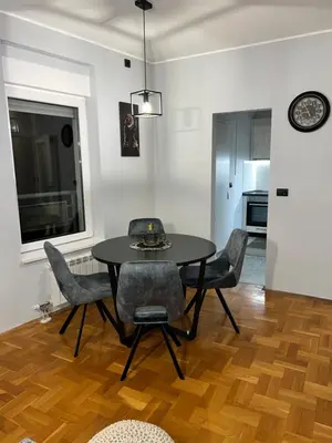 a dining room with a black table and chairs at Fairy tale apartment in Dušanovac (historical)