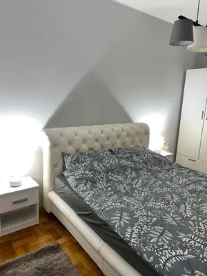 a bedroom with a bed with a black and white blanket at Fairy tale apartment in Dušanovac (historical)