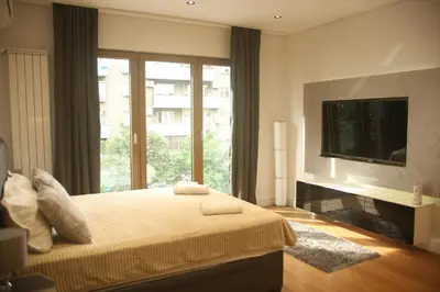 a bedroom with a bed with a tv and a window at Natalie's Condo in Belgrade