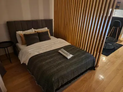 a bed with a remote control sitting on top of it at LL65 Apartments Vracar in Belgrade