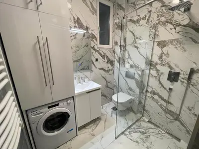 a bathroom with a washing machine and a washer at LL65 Apartments Vracar in Belgrade