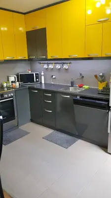 a kitchen with yellow cabinets and stainless steel appliances at NeraBella Apartment in Belgrade