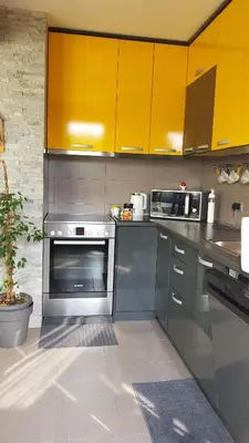 a kitchen with stainless steel appliances and yellow cabinets at NeraBella Apartment in Belgrade