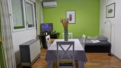 a living room with a table and a bed at NeraBella Apartment in Belgrade