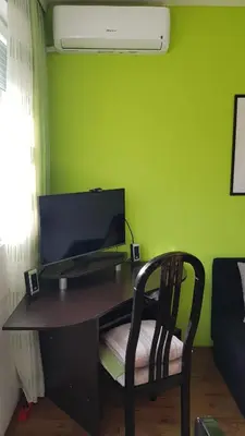 a desk with a computer on a green wall at NeraBella Apartment in Belgrade