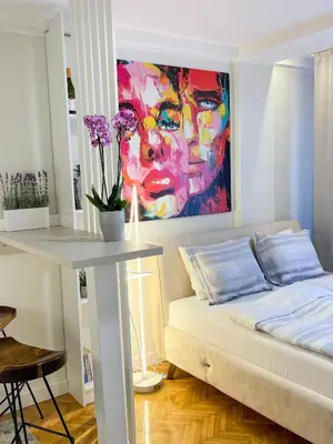 a room with a bed and a painting on the wall at Skadarlija ColorWay in Belgrade