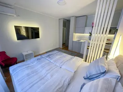a bedroom with a large white bed and a couch at Skadarlija ColorWay in Belgrade