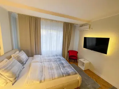 a bedroom with a bed and a flat screen tv at Skadarlija ColorWay in Belgrade