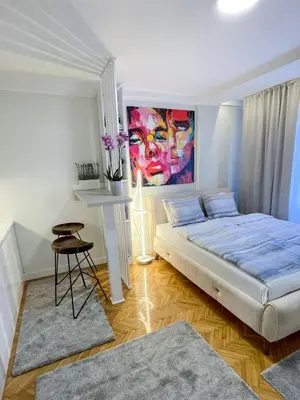 a bedroom with a bed and a painting on the wall at Skadarlija ColorWay in Belgrade