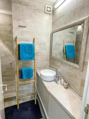 a bathroom with a sink and a mirror and blue towels at Skadarlija ColorWay in Belgrade