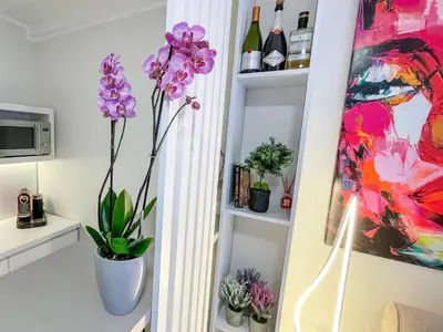 a room with a vase of flowers and a painting at Skadarlija ColorWay in Belgrade