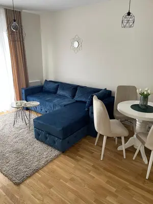a living room with a blue couch and a table at Cvetanov trg LUX 2 in Belgrade