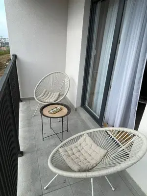 two chairs and a table on a balcony at Cvetanov trg LUX 2 in Belgrade