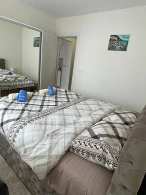 a bedroom with a bed with blue pillows on it at Cvetanov trg LUX 2 in Belgrade