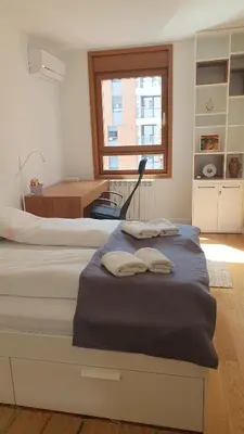 a bedroom with two beds and a desk and a window at Happy Corner New Belgrade in Novi Beograd