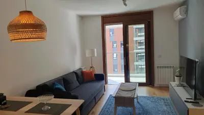 a living room with a blue couch and a tv at Happy Corner New Belgrade in Novi Beograd