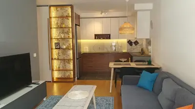 a living room with a couch and a kitchen at Happy Corner New Belgrade in Novi Beograd