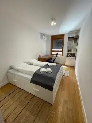 a bedroom with a bed and a desk and a window at Happy Corner New Belgrade in Novi Beograd