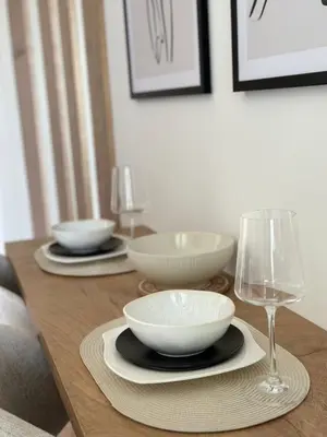 a wooden table with two bowls and a wine glass at Apartman Grand BW in Belgrade