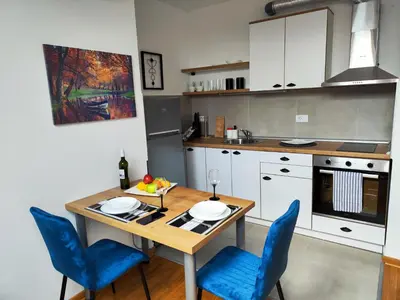 a kitchen with a wooden table and blue chairs at Zvezdara blue star in Zvezdara