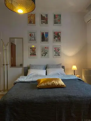 a bedroom with a large bed with a yellow pillow on it at Mala Bella in Zemun