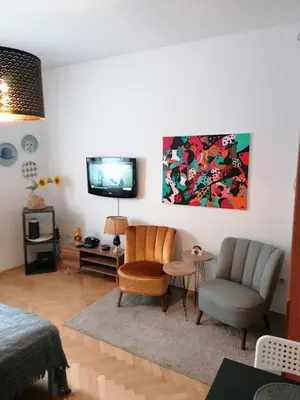 a living room with two chairs and a television at Mala Bella in Zemun