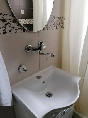 a white sink in a bathroom with a mirror at Mala Bella in Zemun