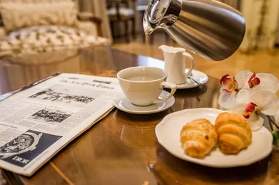 a table with a plate of croissants and a cup of coffee at Hotel Moskva in Belgrade
