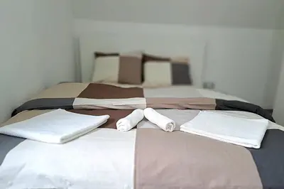 a bed with two beds with towels on it at Mini duplex apartman in Dušanovac (historical)