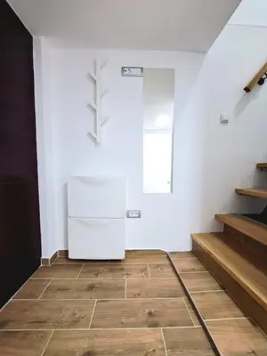 a kitchen with a white refrigerator in a room at Mini duplex apartman in Dušanovac (historical)
