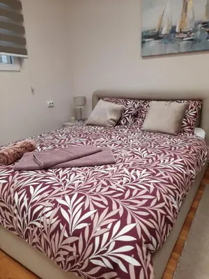 a bed with a black and white comforter and pillows at Aleksa 1 in Belgrade