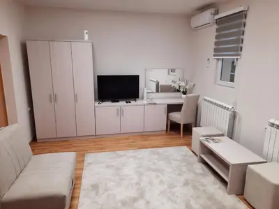 a living room with a couch and a desk with a television at Aleksa 1 in Belgrade