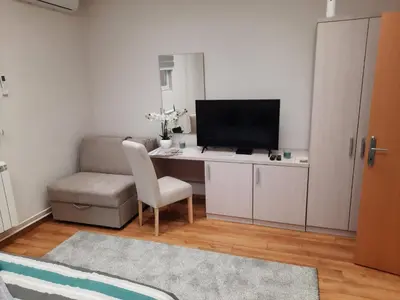 a living room with a desk with a tv and a chair at Aleksa 2 in Belgrade