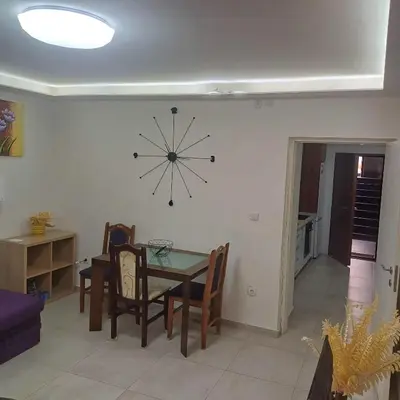 a dining room with a table and a clock on the wall at Jelena in Vračar (historical)
