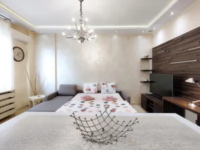 a bedroom with a large bed and a chandelier at Home Center Apartment in Belgrade