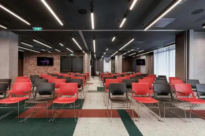 a conference room with red chairs and a screen at Moxy Belgrade in Belgrade