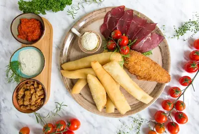 a plate of food with meat and vegetables on a table at Hotel Srbija-FREE PARKING in Belgrade