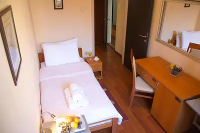 a small room with a bed and a desk and a mirror at Hotel Srbija-FREE PARKING in Belgrade