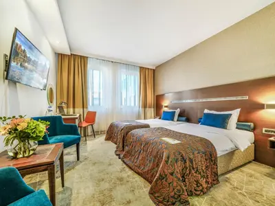 a hotel room with a bed and a table and chairs at IN Hotel Beograd in Belgrade
