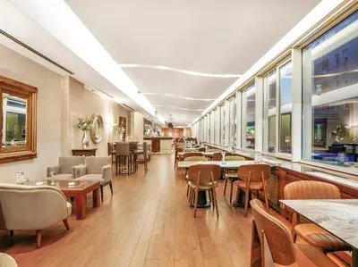 a restaurant with tables and chairs and windows at IN Hotel Beograd in Belgrade