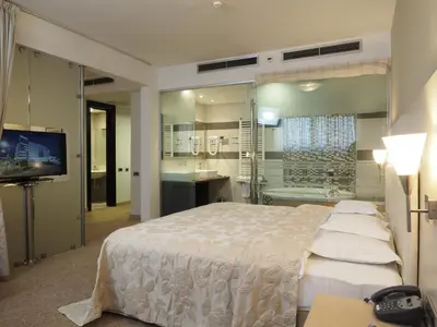 a bedroom with a bed and a tub and a television at IN Hotel Beograd in Belgrade