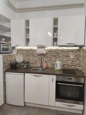 a kitchen with white cabinets and a stove top oven at Zone Dedinje in Dedinje
