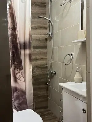 a bathroom with a shower with a toilet and a sink at Bellissima Apartment in Belgrade