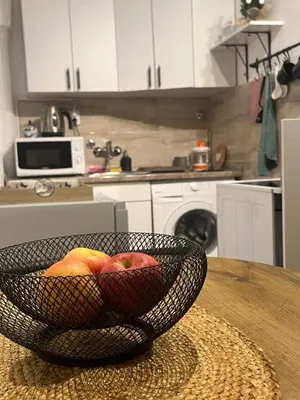 a bowl of apples sitting on a table in a kitchen at Bellissima Apartment in Belgrade