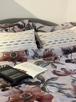 a book on top of a bed with flowers at Bellissima Apartment in Belgrade
