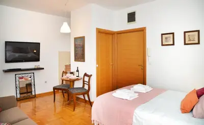 a room with two beds and a table with a chair at Studio Milan in Vračar (historical)