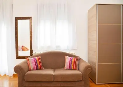 a living room with a couch and a mirror at Studio Milan in Vračar (historical)